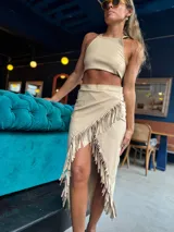 Top beige con cuello halter y espalda descubierta.