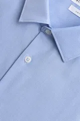 Camisa slim fit de algodón color celeste, con cuello italiano, manga larga y puños con botón. Cierre frontal de botonadura.