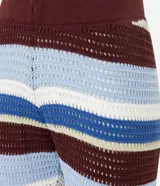Pantalón femenino de punto con efecto crochet, de corte flare, cintura elástica y rayas horizontales en diferentes anchos y colores (azul claro, azul medio, bordó y blanco).