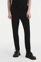 Jean de corte skinny con ajuste estrecho en la pierna, confeccionado en denim elástico color negro. Presenta tiro medio y cierre con bragueta.