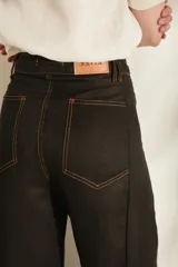 Pantalón de lino blanco de corte wide leg, con diseño amplio y costuras pespunteadas a contratono.
