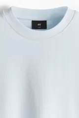 Remera de algodón en punto pesado, color celeste, de corte boxy, cuello redondo ribeteado, hombros caídos y mangas cortas.