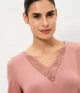 Pijama largo de dos piezas confeccionado en viscolycra color rosado. Incluye una remera de manga corta con escote en V adornado con encaje y un pantalón de corte recto con cintura elástica.