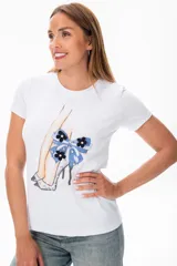Remera blanca de algodón con estampado de piernas con zapatos de tacón y moño azul.