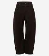 Pantalón de sarga color marrón con corte barrel, cintura media, cierre frontal con botón y cremallera, bolsillos funcionales y recortes estructurales en las piernas.