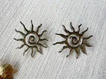 Aros de acero plateado con diseño de sol y centro en espiral.