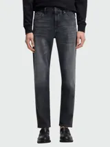 Jean de corte regular fit en color gris oscuro con efecto lavado, confeccionado en denim de alta calidad con cierre de botón y cremallera.