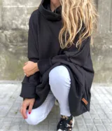 Canguro negro oversize con cuello alto, mangas largas con puños ajustados y bolsillo tipo parche con etiqueta de cuero en el ruedo.
