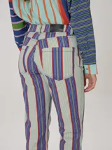 Pantalón de corte recto con diseño de rayas verticales multicolor en tonos celeste, azul, violeta y naranja.
