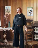 Canguro negro de corte oversize, con capucha ajustable mediante cordones y bolsillo frontal tipo canguro. Presenta un estampado frontal con la palabra 'KABOA' en tipografía gótica de color verde claro.