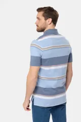 Remera polo de manga corta con cuello y puños en azul oscuro. Presenta un diseño de rayas horizontales en tonos de azul claro, azul oscuro, blanco, amarillo, rosa y verde. Incluye botones personalizados y un logo bordado en el pecho.