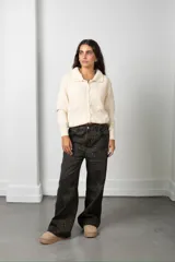 Saco tejido de punto color blanco, con cuello tipo polo, cierre frontal con botones y diseño con flores bordadas en relieve.