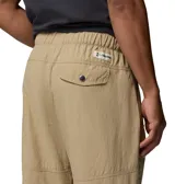 Pantalón convertible Columbia modelo Acker Rock Convert, color beige, de corte holgado y diseño cargo con múltiples bolsillos, bolsillos laterales con solapa y parche de la marca. Las perneras se desmontan mediante cremalleras para convertirlo en short.