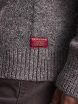Sweater de cuello redondo confeccionado en mezcla de lana, con diseño de tejido de punto y sutiles líneas verticales en contraste.