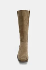 Bota de caña alta confeccionada en serraje, con diseño pull-on de calce fácil. Presenta detalle de doble tirador superior, pespuntes decorativos en el cuerpo, tacón bajo en bloque y punta cuadrada.