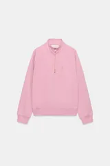 Sudadera de algodón color rosado con cuello alto, cierre frontal con cremallera dorada y manga larga. Presenta un detalle de aplicación metálica con las letras ZA en el pecho y acabados en rib en puños y ruedo.