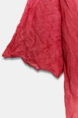 Top rojo de punto con textura efecto arrugado, cuello redondo y mangas cortas holgadas.