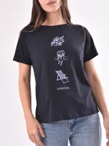 Remera negra de manga corta con estampado gráfico lineal en color blanco en el centro del pecho que incluye ilustraciones de frutas, copas brindando, una reposera y la inscripción "La Dolce Vita".