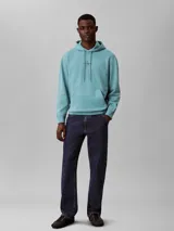 Buzo canguro Calvin Klein de color celeste, confeccionado en tejido French Terry. Presenta capucha con cordones ajustables, bolsillo frontal tipo canguro, puños y dobladillo acanalados, y el monograma de la marca bordado en el pecho.