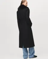 Abrigo largo de lana italiana Manteco, de corte recto y diseño estructurado. Presenta cuello con solapas y cuello de pelo sintético desmontable. Incluye cinturón tipo batín para ajuste en la cintura, dos bolsillos laterales y forro interior completo.