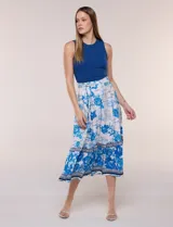 Vestido midi combinado de la marca Figueroa & Flower, con torso de modal azul sin mangas y cuello redondo, y falda evasé de rayón con estampado floral y paisajes en tonos blancos y azules, con cintura elastizada y lazo para anudar.