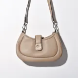 Bandolera color beige con correa larga regulable y cierre con broche.