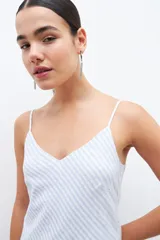 Maxi vestido celeste con rayas verticales blancas y plateadas, breteles finos y corte al bies.