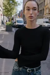 Camiseta de cuello redondo y manga larga con terminación acampanada en los puños, de corte ajustado al cuerpo.