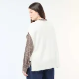 Sweater sin mangas de tejido de punto en color beige, con cuello redondo y diseño holgado con aberturas laterales ajustables mediante lazos.