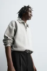 Polo de punto de corte relajado, confeccionado en mezcla de algodón, con cuello solapa, cierre frontal de cremallera y manga larga con acabados en rib.