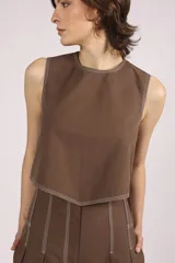 Blusa crop top negra sin mangas con cuello redondo y pespuntes blancos contrastantes.