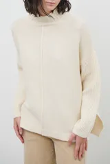 Polera de tejido de punto color chocolate, con cuello alto, mangas largas con puños acanalados y detalle de costura central vertical. Incluye una pequeña etiqueta de cuero sintético en el ruedo.