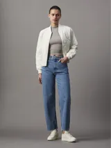 Campera bomber color blanco, acolchada con patrón de rombos, cuello, puños y ruedo acanalados, cierre frontal con cremallera y logo de la marca en el pecho.