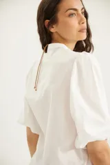 Camisa de algodón celeste con cuello mao, pechera con botones ocultos y mangas abullonadas con puños elásticos.