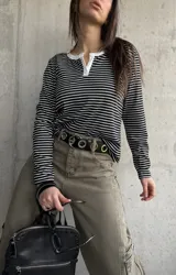 Remera rayada en blanco y negro de manga larga, con cuello redondo y cartera de botones frontal en contraste blanco.