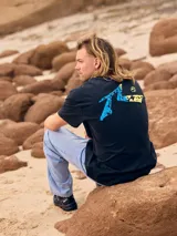 Remera negra de hombre con estampa azul y amarilla en la espalda.