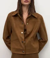 Chaqueta de corte recto confeccionada en suede sintético color marrón. Presenta cuello estilo camisa, cierre frontal con botones metálicos, mangas largas con puños ajustados y bolsillos embutidos.
