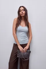Musculosa básica celeste de calce ajustado, confeccionada en tejido acanalado, con escote redondo y breteles finos.