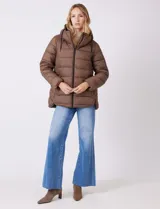 Campera puffer color marrón con capitoneado horizontal. Tiene cuello alto y capucha ajustable con cordones, con el interior del cuello en textura aterciopelada negra. Cierre frontal completo y bolsillos laterales. El corte es ligeramente más largo en la parte posterior con aberturas laterales redondeadas.