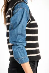 Chaleco de punto negro con rayas horizontales color crema, cuello alto y corte ajustado.