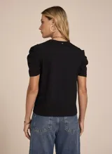 Remera negra de tejido de punto con estampado frontal de la palabra 'Glamour' y dos labiales. Tiene escote redondo, hombros fruncidos abullonados y mangas cortas.