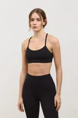 Top deportivo negro de compresión media, con escote redondo clásico, tiras finas cruzadas en la espalda y tazas intercambiables.