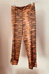 Pantalón de tiro alto, ajustado en cintura y cadera y suelto en las piernas. Largo hasta el tobillo con un dobladillo en su ruedo. De diseño simple con estampado de cebra y besos.