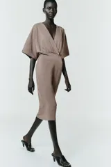 Vestido midi de escote en pico cruzado y manga corta. Presenta detalle de frunces en la cintura y un cinturón integrado con hebilla metálica a contraste.