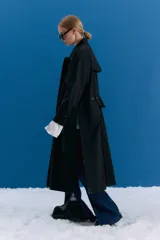 Trench midi color negro, confeccionado en mezcla de algodón y nylon con acabado repelente al agua. Presenta diseño con tajos laterales, bolsillos internos y etiqueta de marca en la espalda.