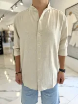Camisa oversize de lino color beige, con cuello mao y mangas largas.