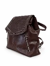Mochila de cuero vacuno marrón con acabado pulido, solapa en forma de V y costuras decorativas. Cuenta con cremalleras laterales y asas ajustables.