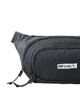 Riñonera Rip Curl modelo Waist Bag Icon, de color negro con cierre frontal y etiqueta con el logotipo de la marca.