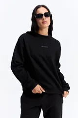 Buzo de algodón color crema, con cuello redondo, mangas largas y calce relajado. Presenta el logo de la marca bordado en el centro del pecho.