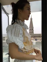 Remera blanca de algodón con estampado color cobre y mangas de broderie negro con elástico.